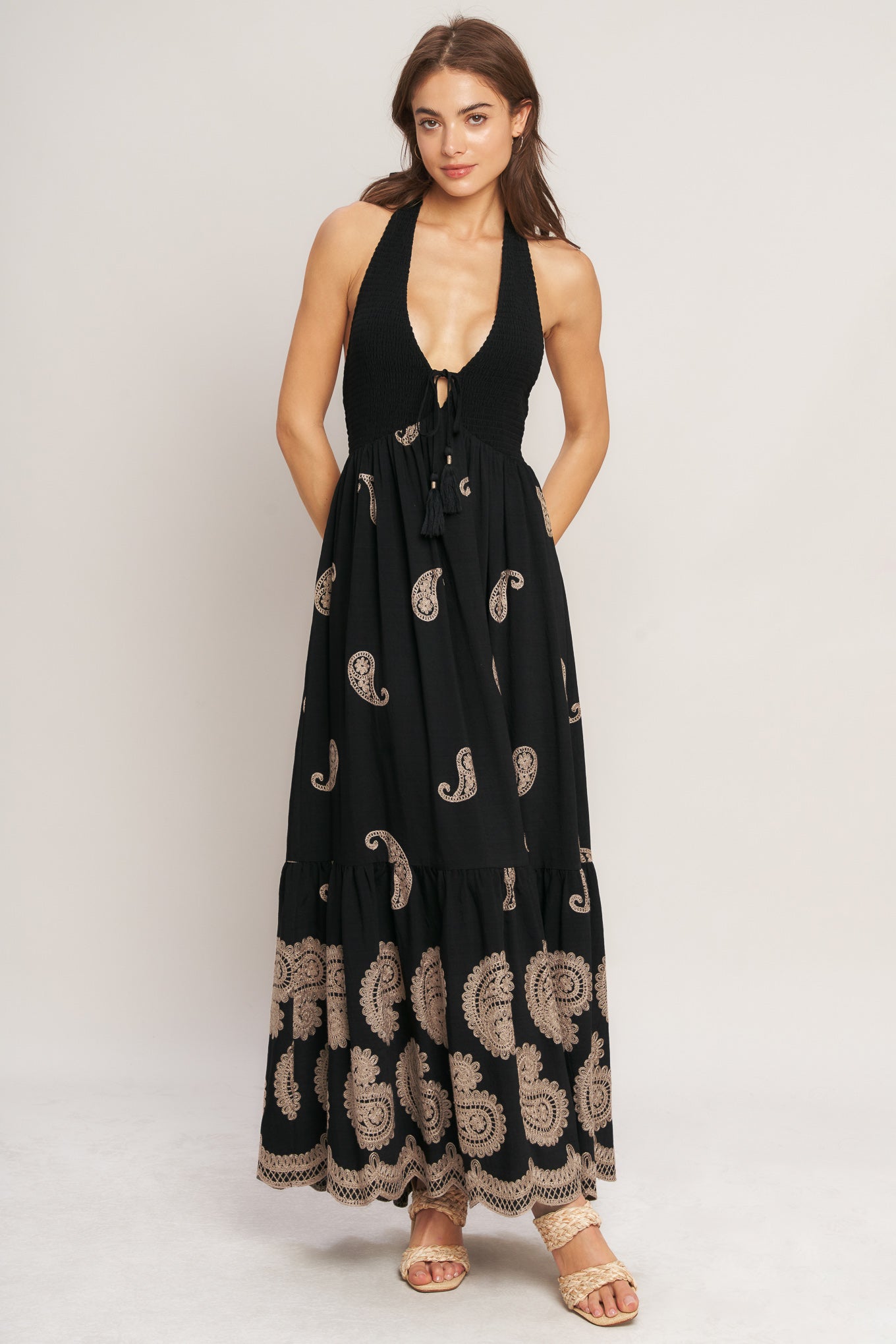 An embroidered woven midi dress featuring halter neckline, smocked bodice with front tie and bare back with back neck tie closure