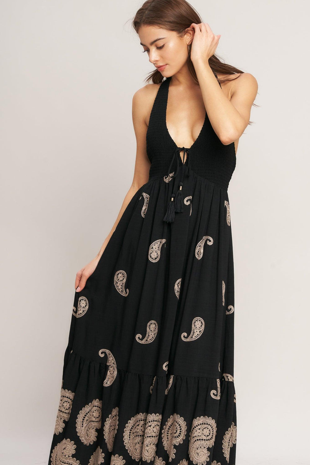 An embroidered woven midi dress featuring halter neckline, smocked bodice with front tie and bare back with back neck tie closure
