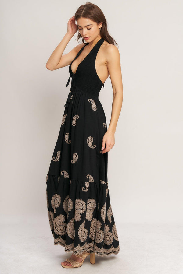 An embroidered woven midi dress featuring halter neckline, smocked bodice with front tie and bare back with back neck tie closure