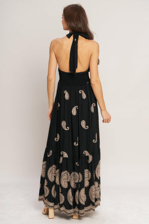 An embroidered woven midi dress featuring halter neckline, smocked bodice with front tie and bare back with back neck tie closure