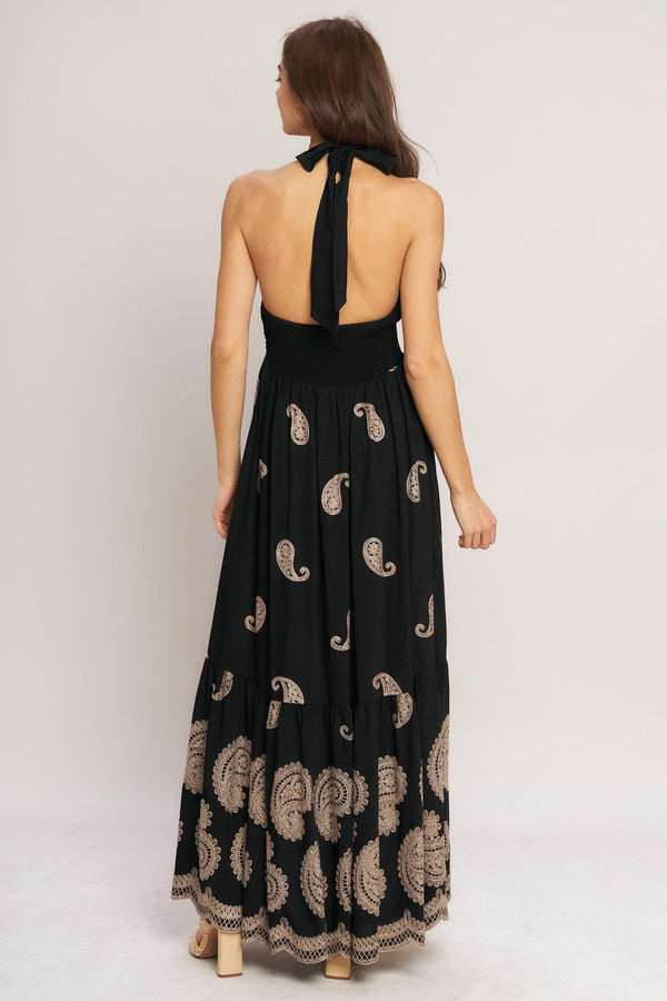 An embroidered woven midi dress featuring halter neckline, smocked bodice with front tie and bare back with back neck tie closure
