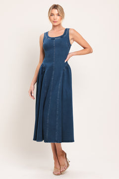 Woman wearing a sleeveless blue denim midi dress featuring U neckline, shirred side full skirt and back zipper closure | Flying Tomato