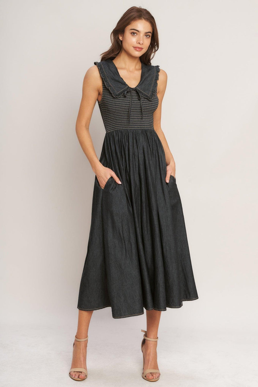 A solid woven midi dress featuring V neckline with ruffled chelsea collar and smocked bodice