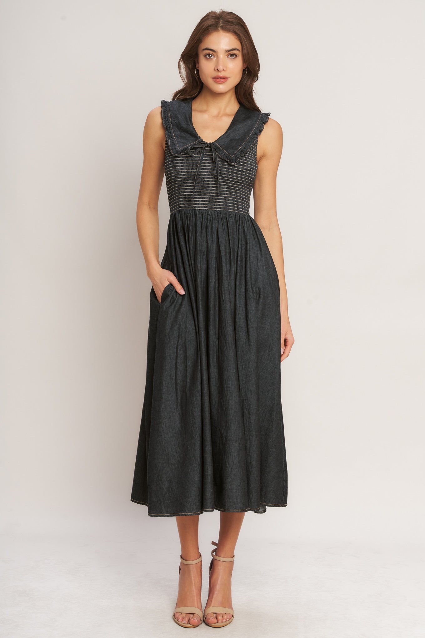 A solid woven midi dress featuring V neckline with ruffled chelsea collar and smocked bodice