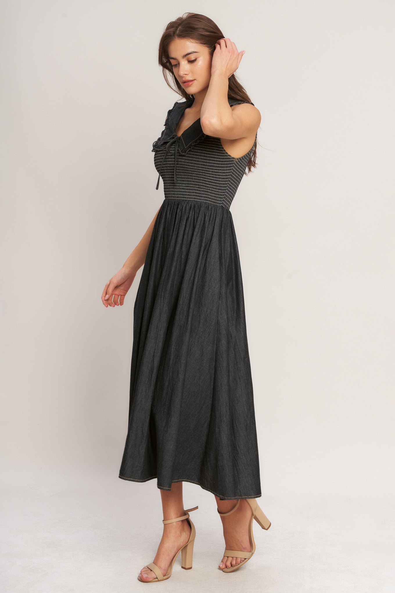 A solid woven midi dress featuring V neckline with ruffled chelsea collar and smocked bodice