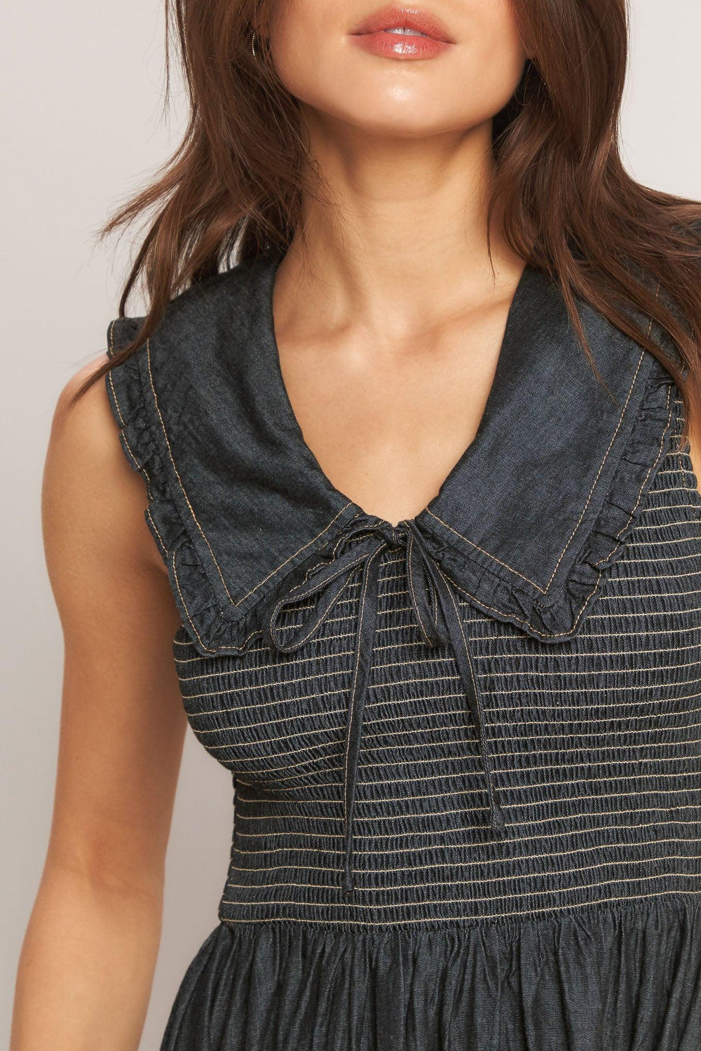 A solid woven midi dress featuring V neckline with ruffled chelsea collar and smocked bodice