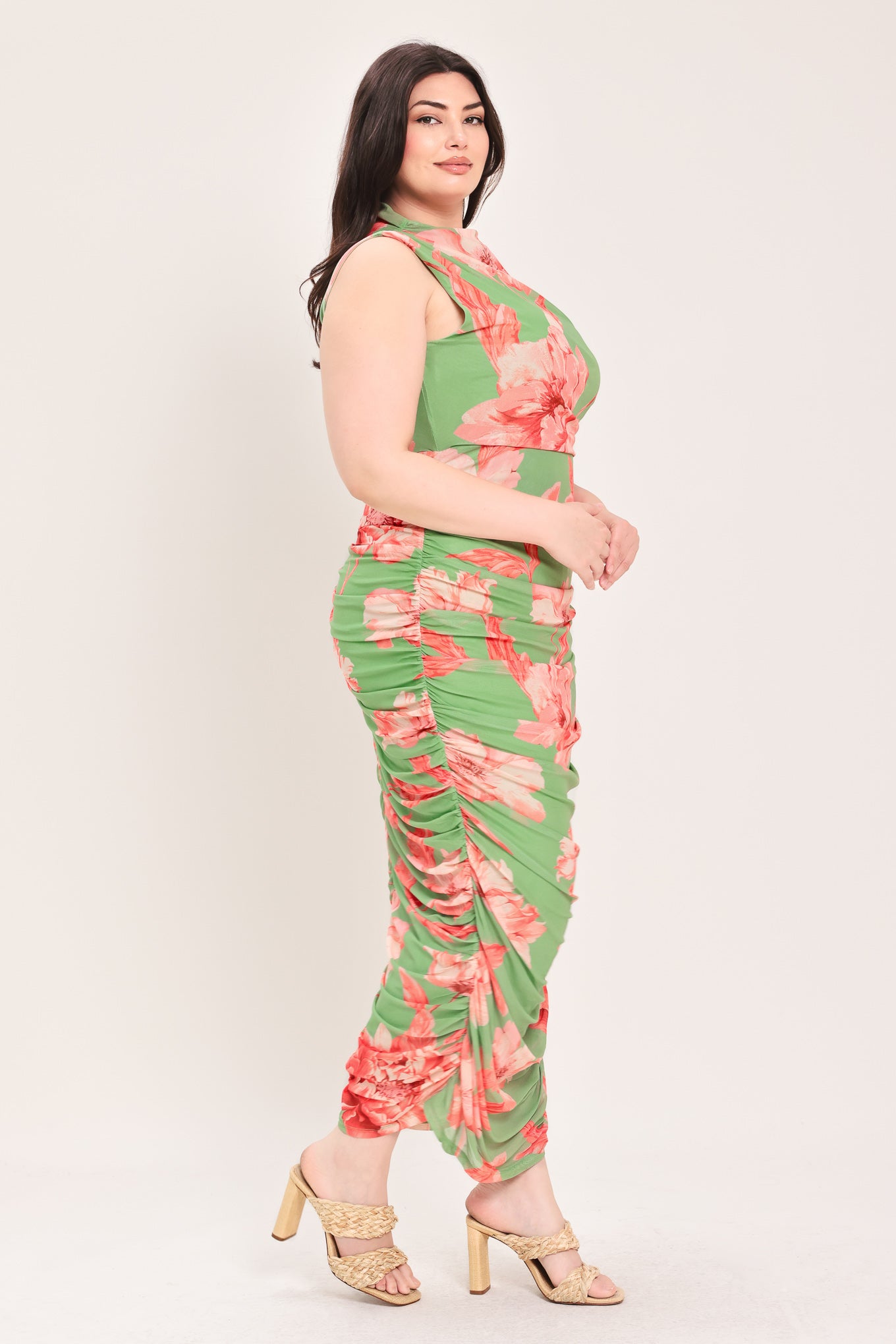 Woman wearing a sage green and pink floral printed power mesh midi dress featuring tubular neckline, sleeveless and shirred body | Flying Tomato