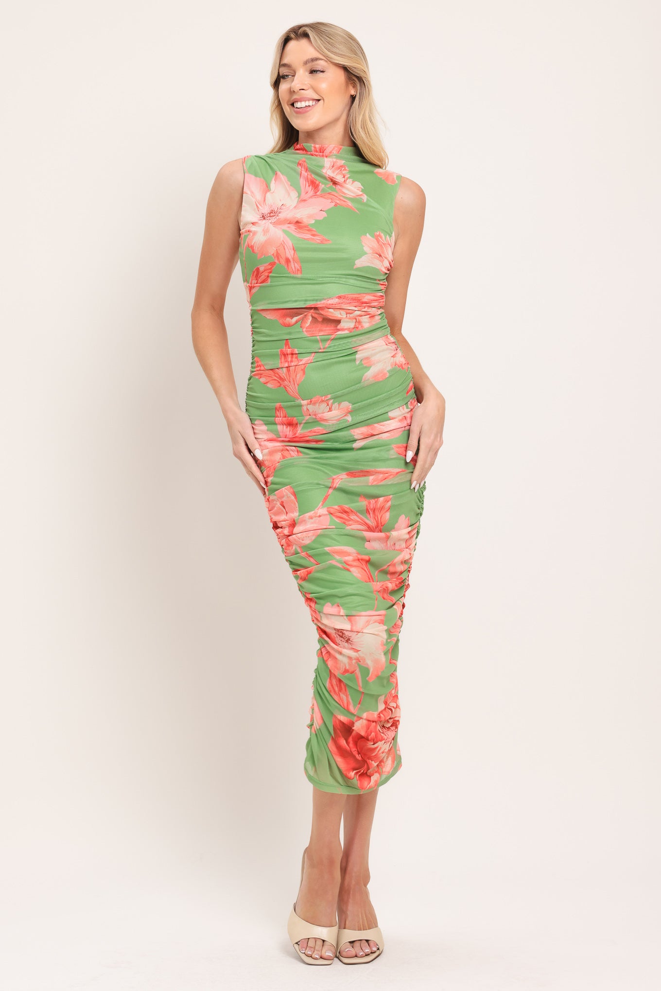 Woman wearing a sage green and pink floral printed power mesh midi dress featuring tubular neckline, sleeveless and shirred body | Flying Tomato