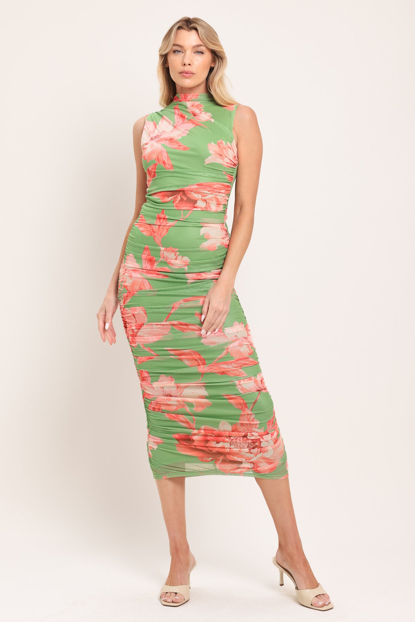 Woman wearing a sage green and pink floral printed power mesh midi dress featuring tubular neckline, sleeveless and shirred body | Flying Tomato