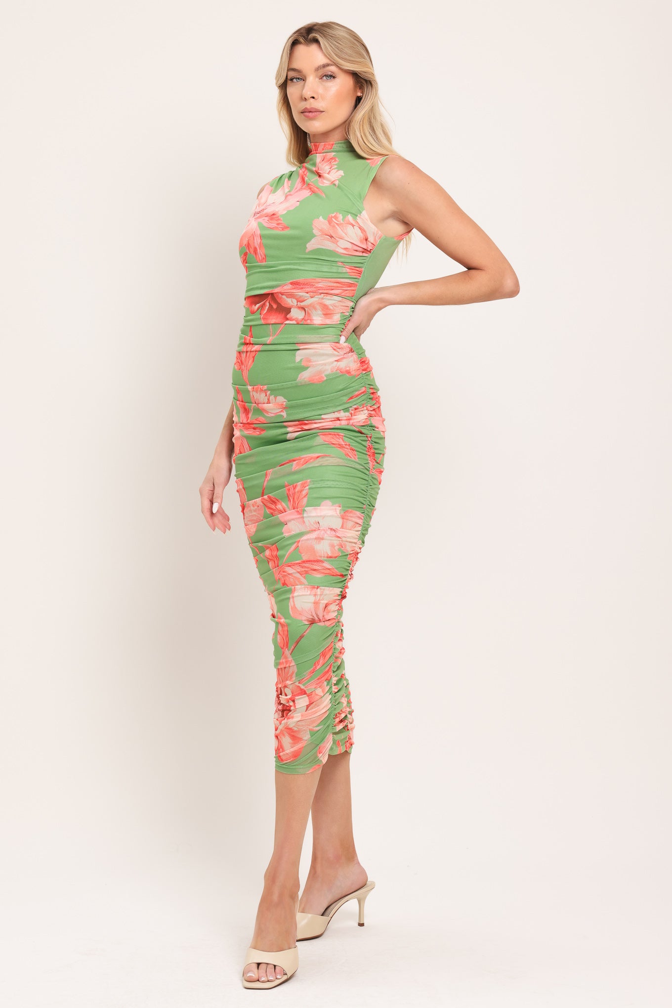 Woman wearing a sage green and pink floral printed power mesh midi dress featuring tubular neckline, sleeveless and shirred body | Flying Tomato