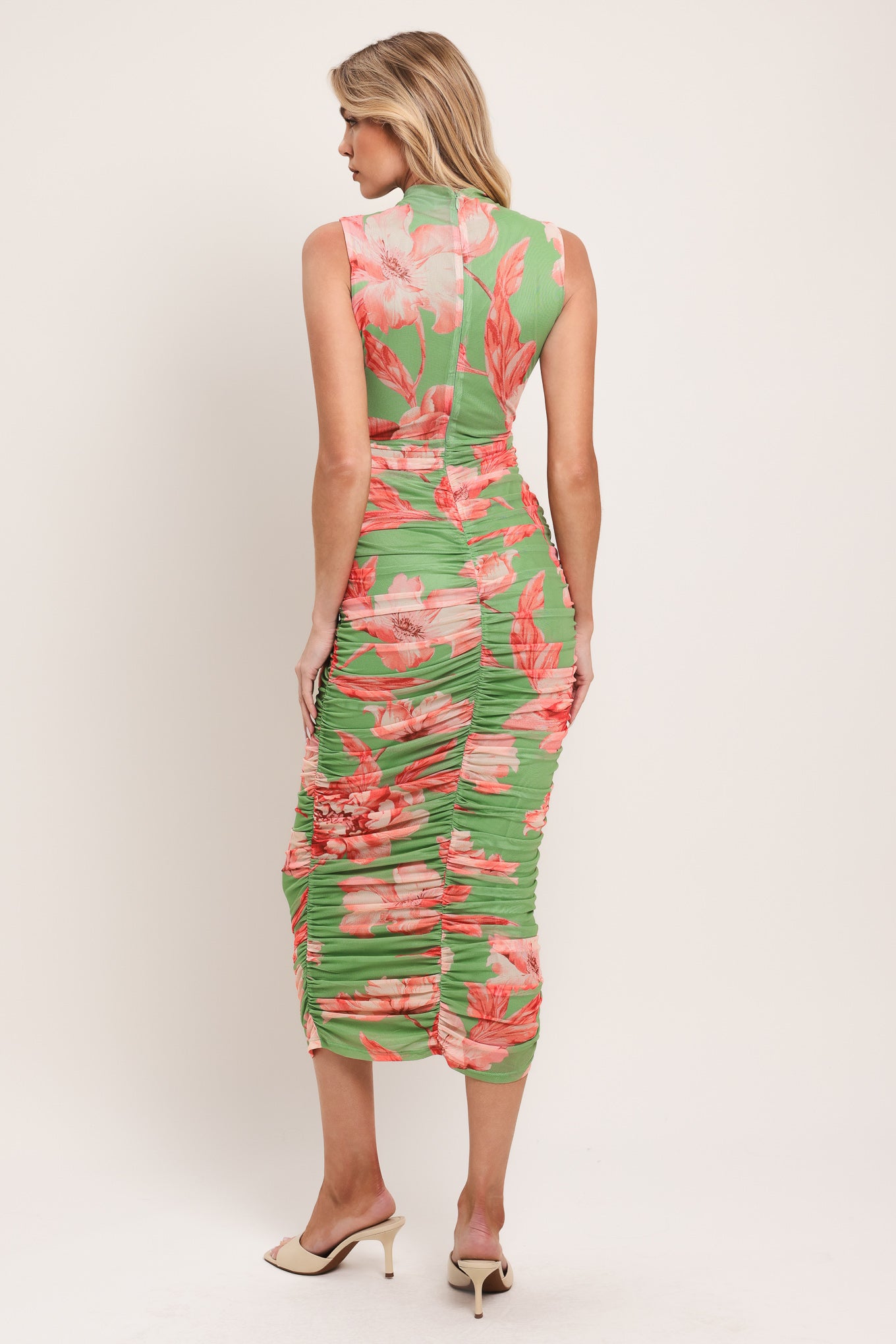 Woman wearing a sage green and pink floral printed power mesh midi dress featuring tubular neckline, sleeveless and shirred body | Flying Tomato
