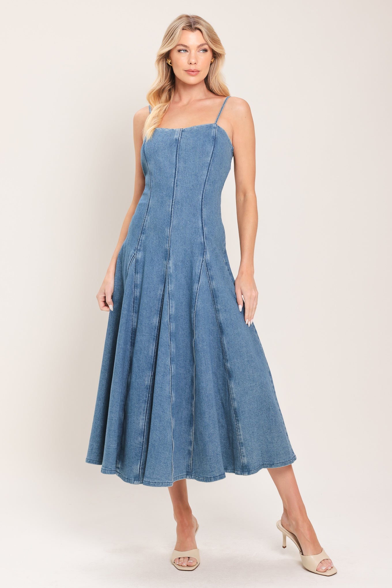 Woman wearing a denim midi dress featuring straight neckline, straps, full circle skirt and back zipper closure | Flying Tomato