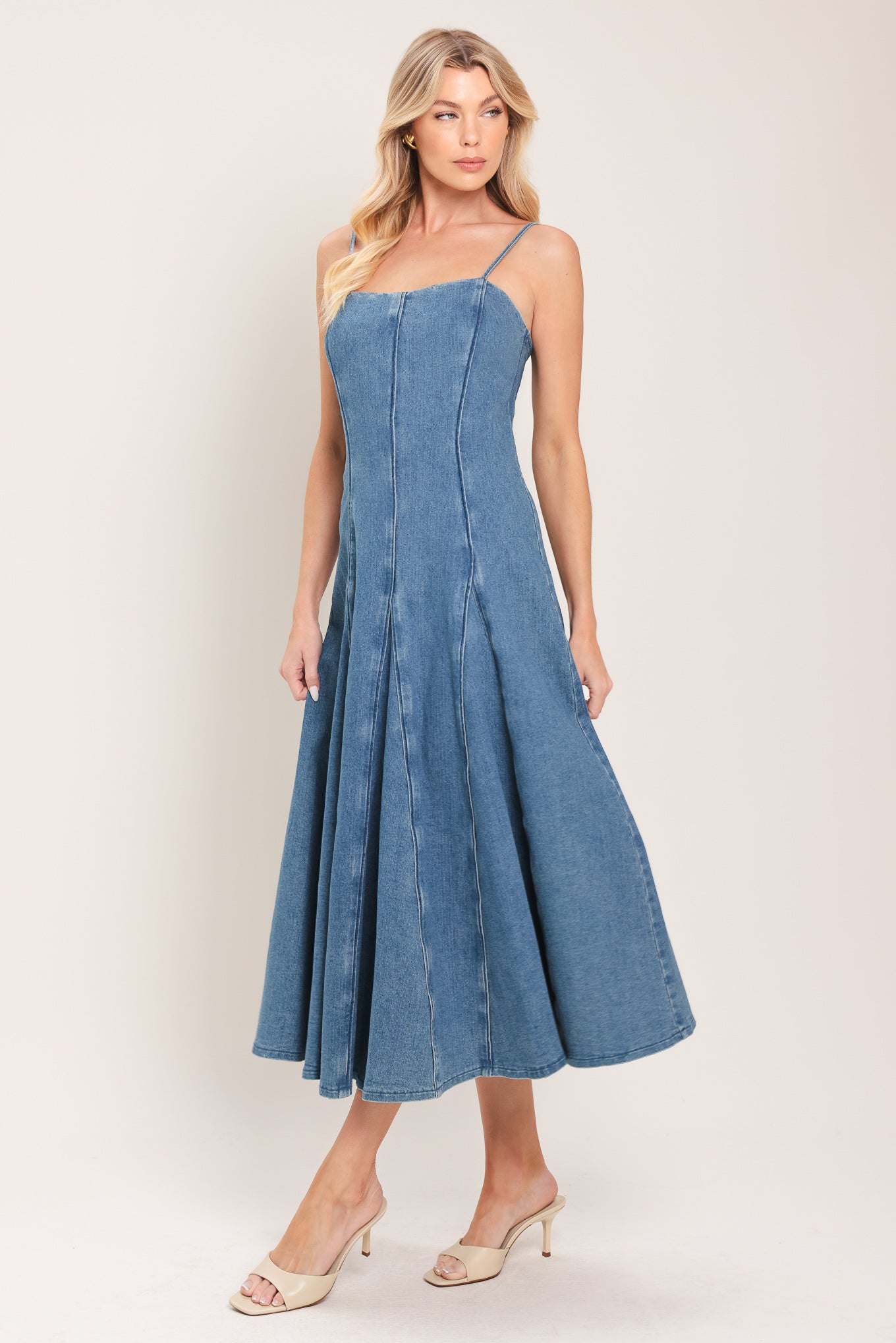 Woman wearing a denim midi dress featuring straight neckline, straps, full circle skirt and back zipper closure | Flying Tomato