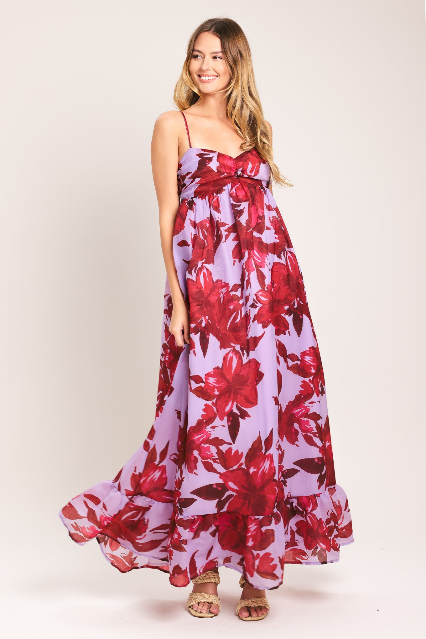 Woman wearing a lavender and berry color, floral printed woven ankle dress featuring sweetheart neckline, straps, cinched at center bust, ruffle hem and smocked back bodice | Flying Tomato