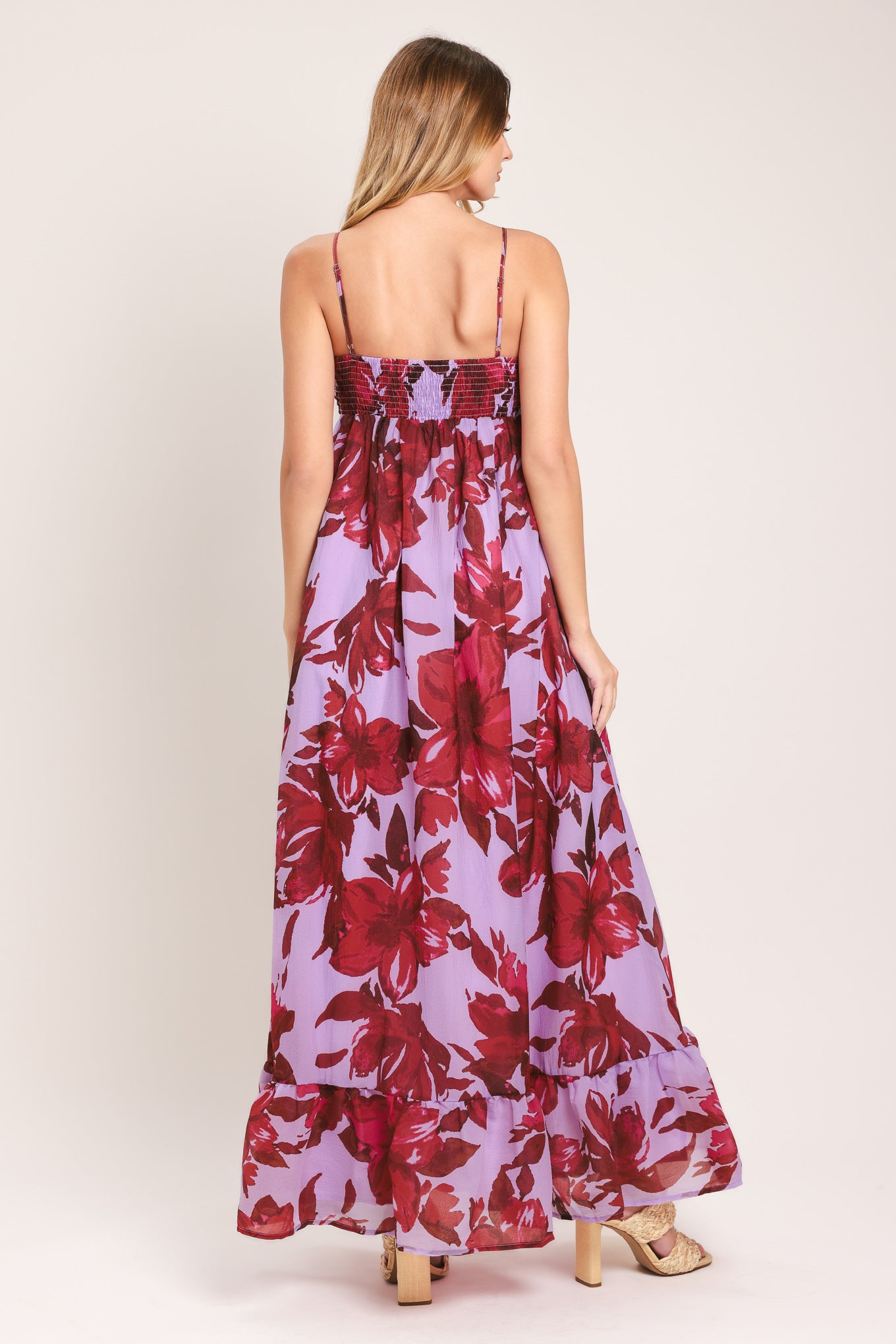 Woman wearing a lavender and berry color, floral printed woven ankle dress featuring sweetheart neckline, straps, cinched at center bust, ruffle hem and smocked back bodice | Flying Tomato