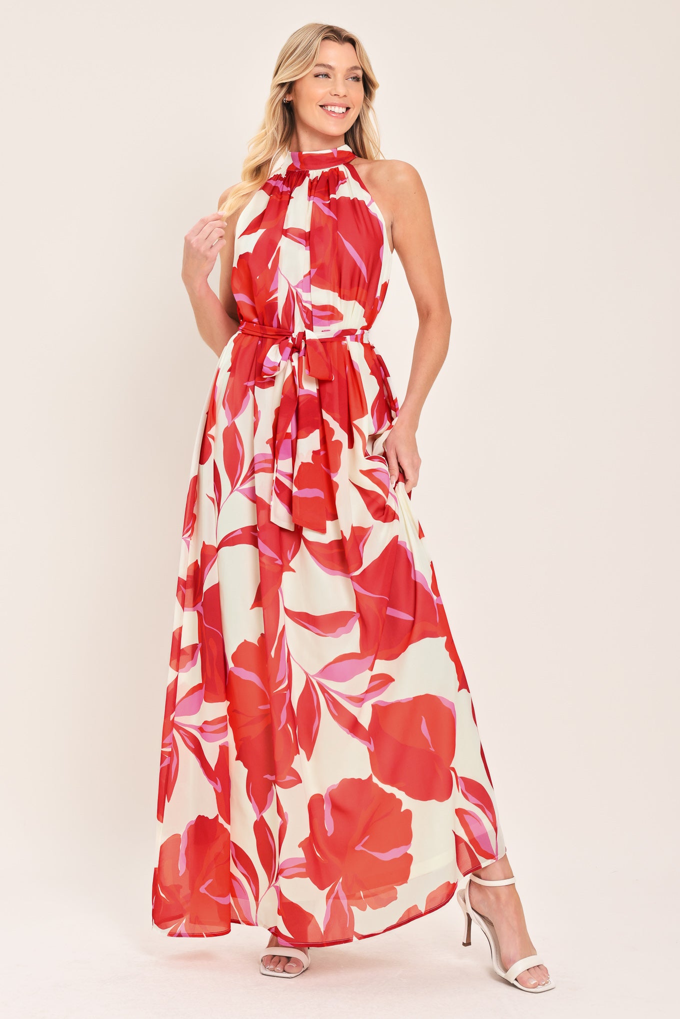 Woman wearing a red floral maxi dress with halter neckline, self sash tie and back button closure | Flying Tomato
