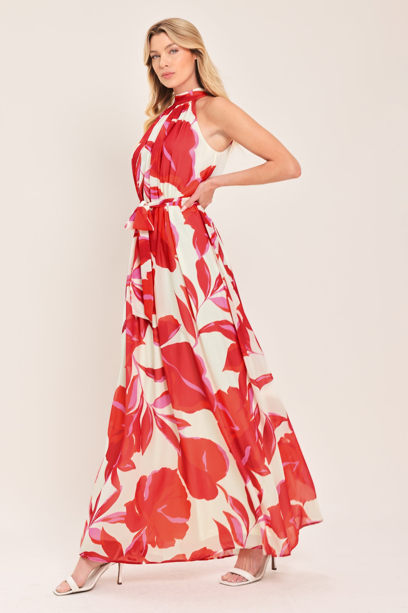 Woman wearing a red floral maxi dress with halter neckline, self sash tie and back button closure | Flying Tomato