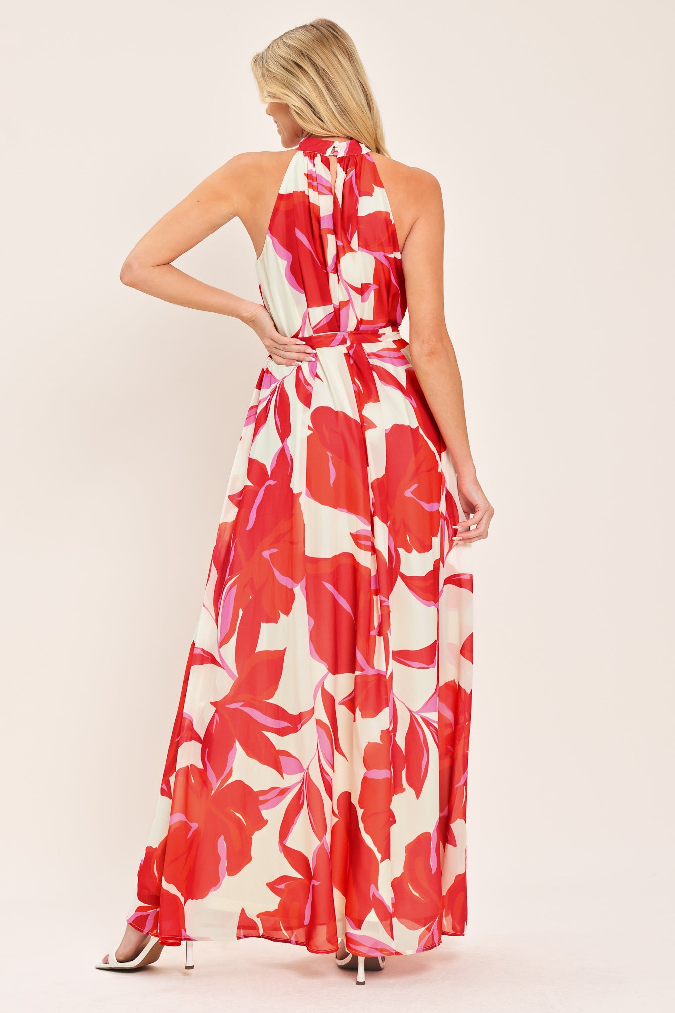 Woman wearing a red floral maxi dress with halter neckline, self sash tie and back button closure | Flying Tomato