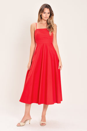 Woman wearing a red midi dress featuring straight neckline, straps, pleated waistband, circle skirt and back zipper closure | Flying Tomato
