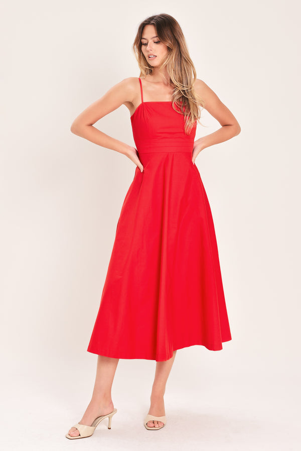 Woman wearing a red midi dress featuring straight neckline, straps, pleated waistband, circle skirt and back zipper closure | Flying Tomato