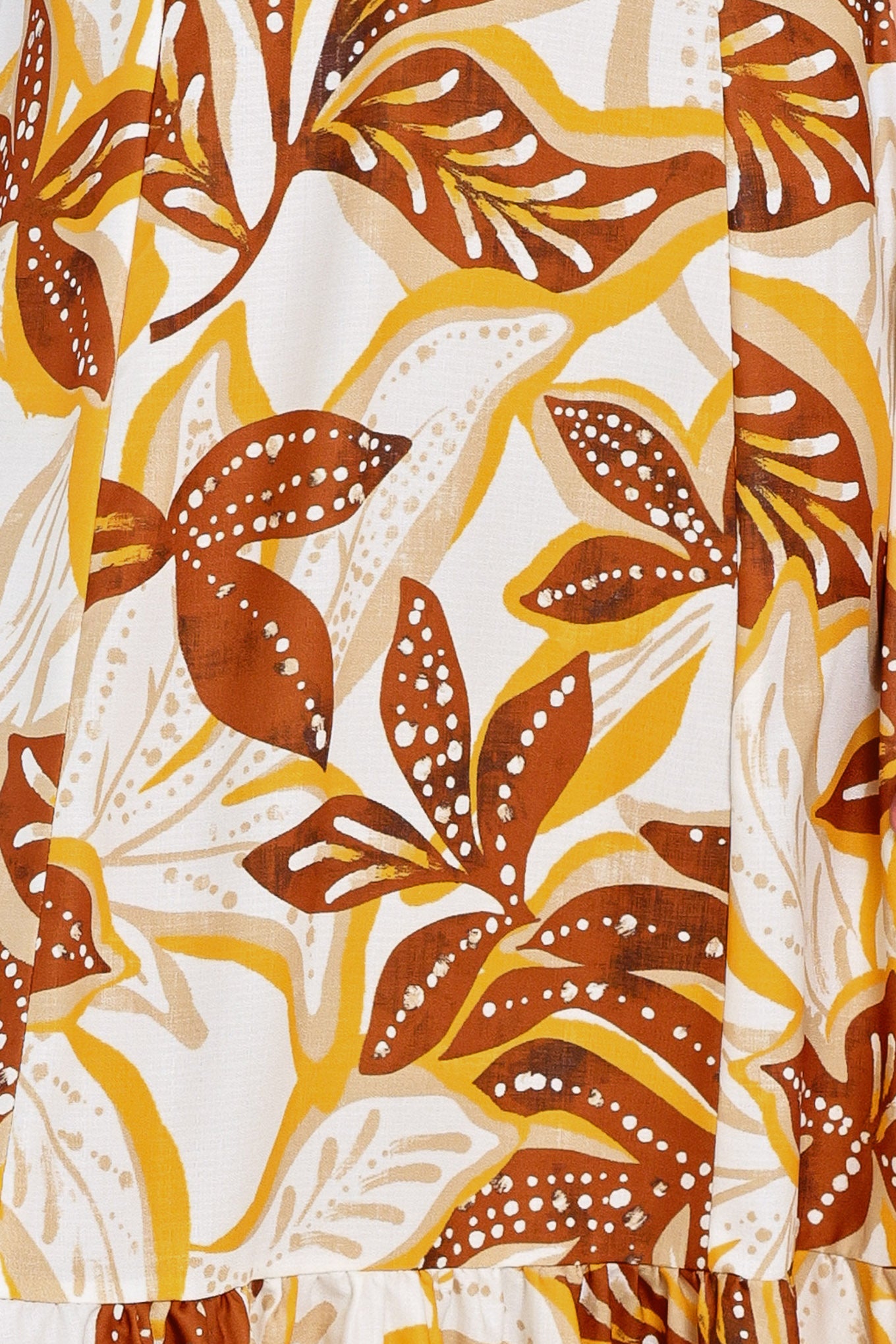 Close up of a mustard and brown tropical printed maxi dress featuring halter tie, ruffle hem and back zipper closure | Flying Tomato