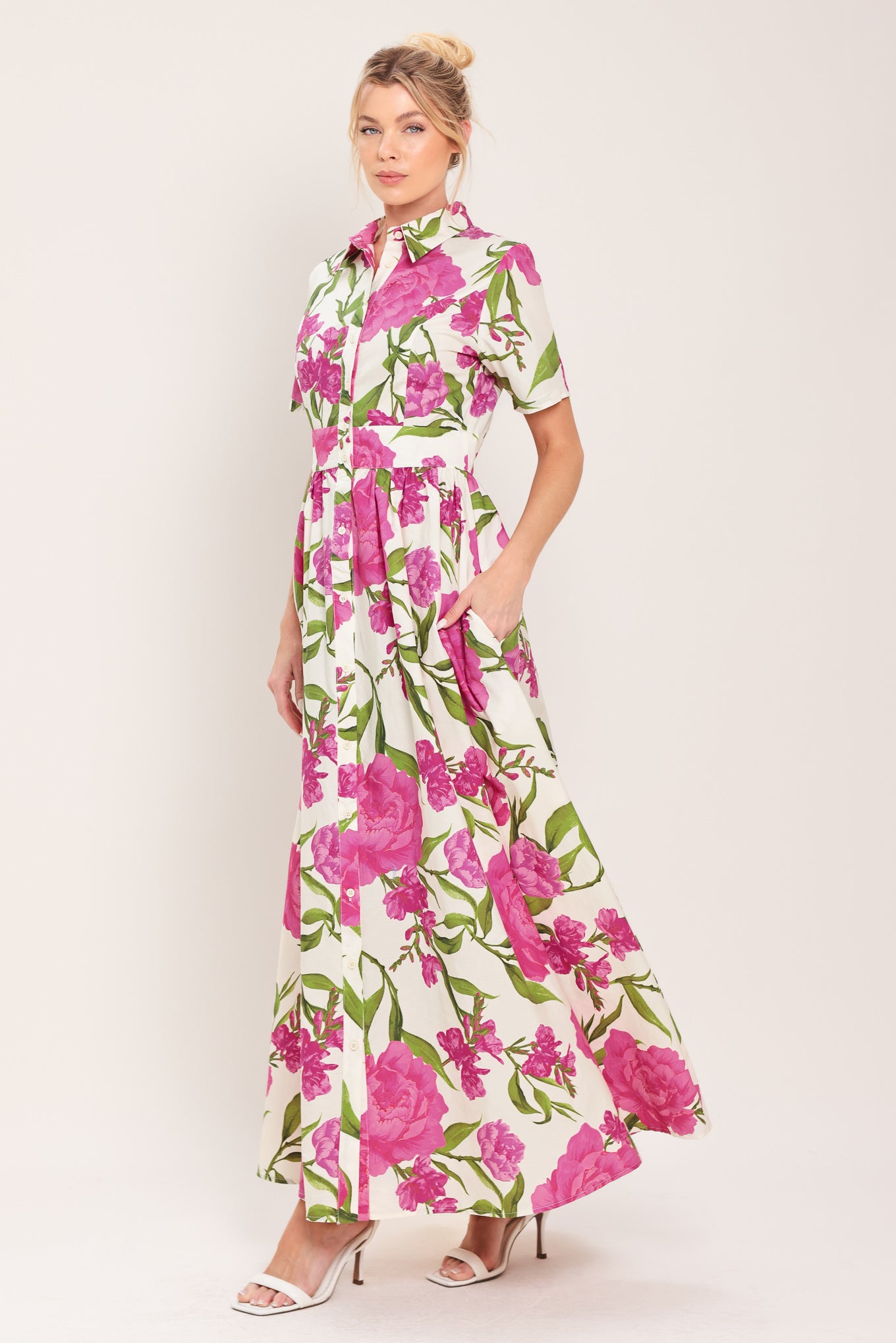 Woman wearing a short sleeve white shirt maxi dress wit pink floral print featuring front button down and full skirt | Flying Tomato