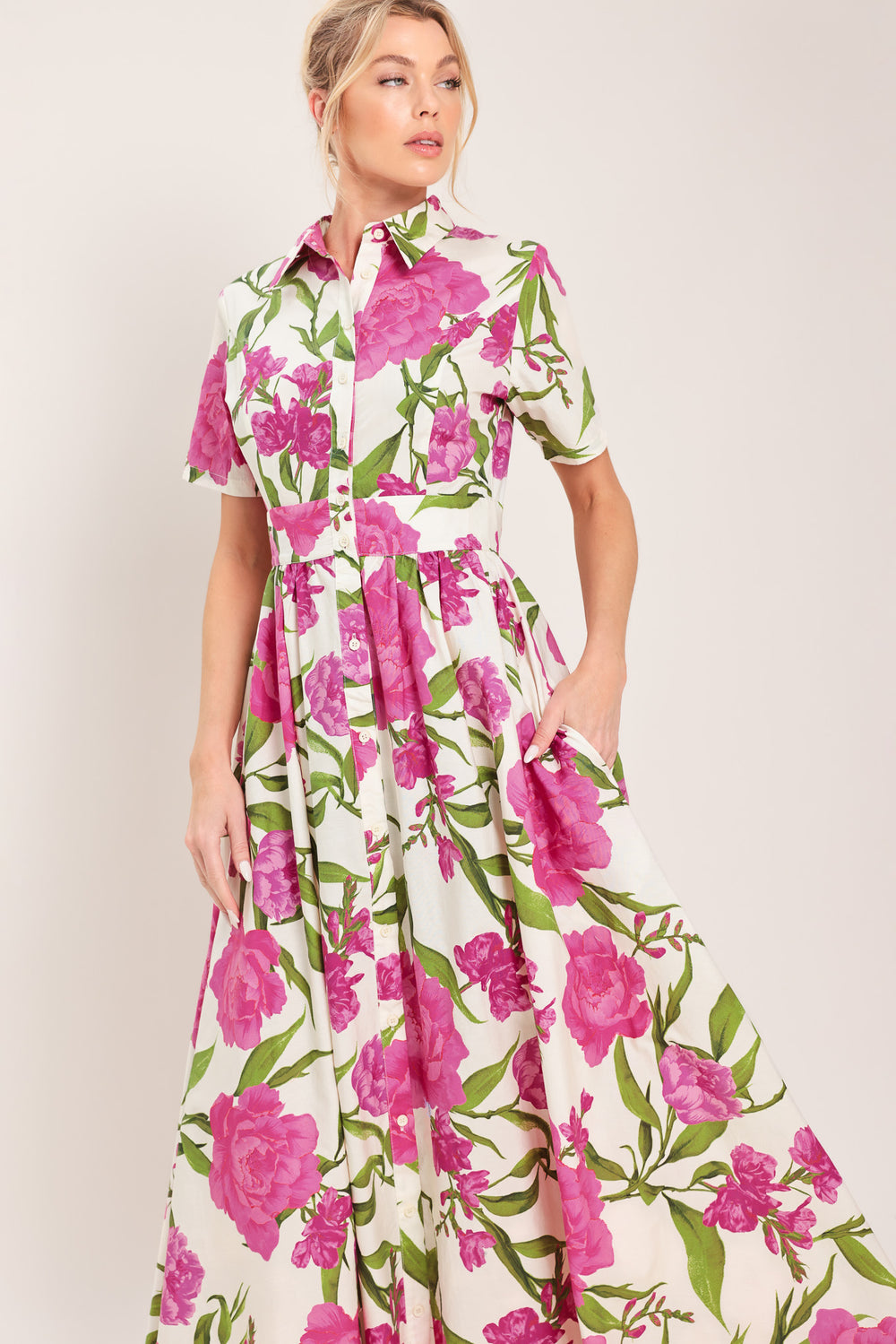 Woman wearing a short sleeve white shirt maxi dress wit pink floral print featuring front button down and full skirt | Flying Tomato