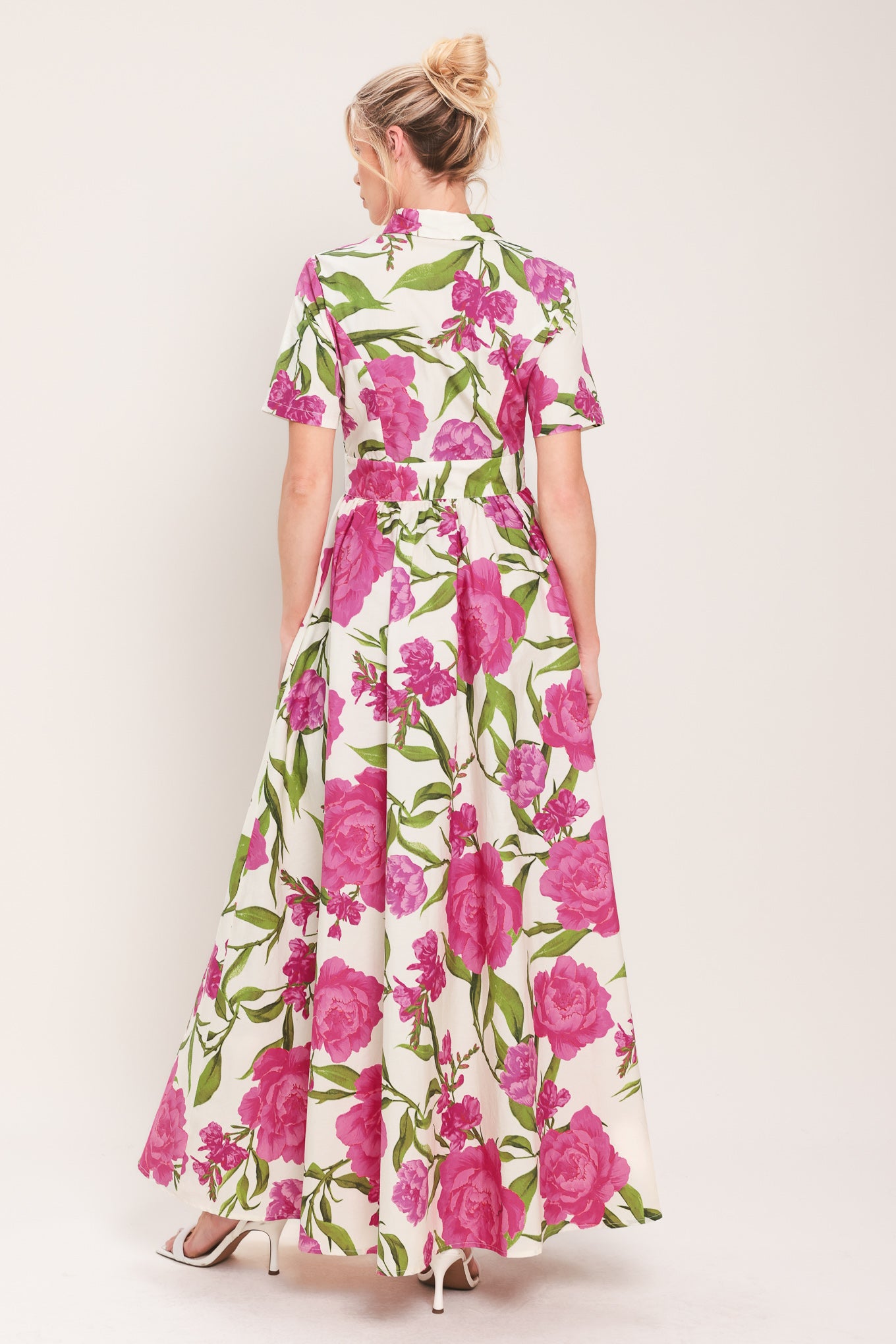 Woman wearing a short sleeve white shirt maxi dress wit pink floral print featuring front button down and full skirt | Flying Tomato