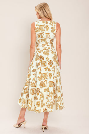 Woman wearing a yellow fruit and Mediterranean objects printed midi dress featuring square neckline, sleeveless, button down detail, circle skirt and back zipper closure | Flying Tomato