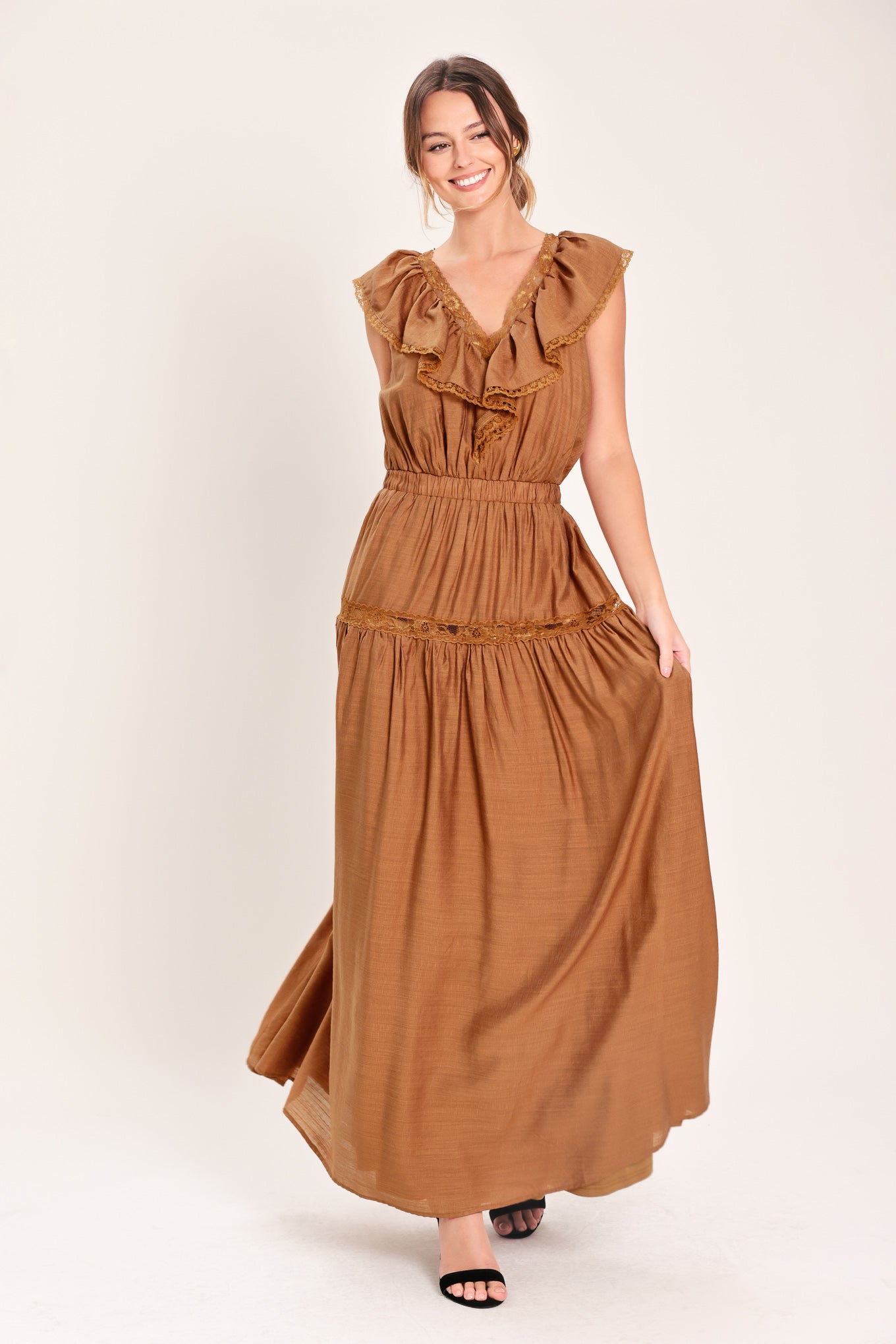 Woman wearing a brown maxi dress featuring V neckline with ruffle and lace edge, elastic waist and back tie | Flying Tomato