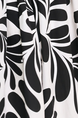 Close up of a black and white maxi dress featuring square neckline, sleeveless, full skirt, cut out back and button zipper closure | Flying Tomato