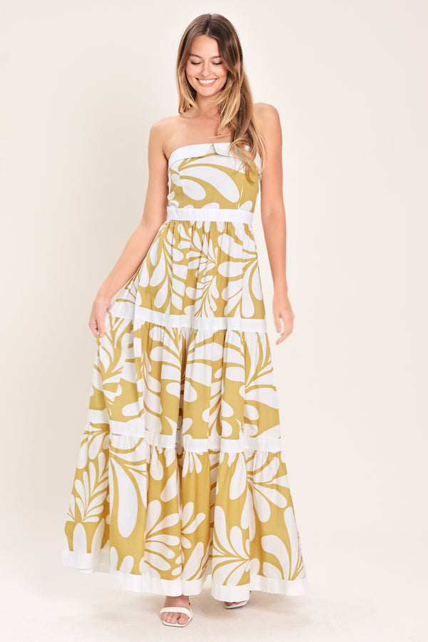 Woman wearing a beige and white  maxi dress featuring strapless neckline, tier skirt and back zipper closure | Flying Tomato