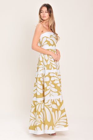 Woman wearing a beige and white  maxi dress featuring strapless neckline, tier skirt and back zipper closure | Flying Tomato