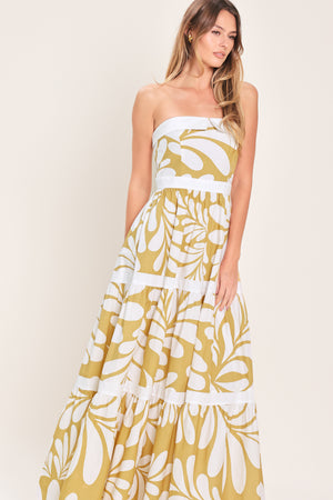 Woman wearing a beige and white  maxi dress featuring strapless neckline, tier skirt and back zipper closure | Flying Tomato