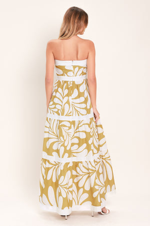 Woman wearing a beige and white  maxi dress featuring strapless neckline, tier skirt and back zipper closure | Flying Tomato