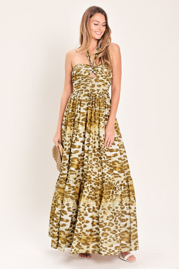 Woman wearing a leopard print maxi dress featuring halter neckline, front center cut out, ruffle hem and smocked back bodice | Flying Tomato