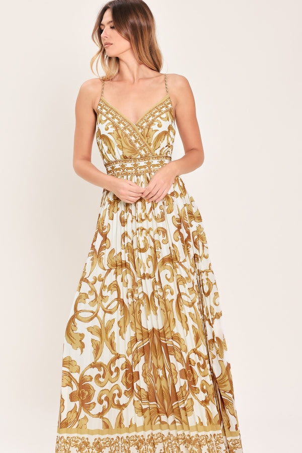 Woman wearing a gold and white baroque patterned maxi dress featuring surplice neckline, straps, pleated skirt and smocked back waistband | FLYING TOMATO