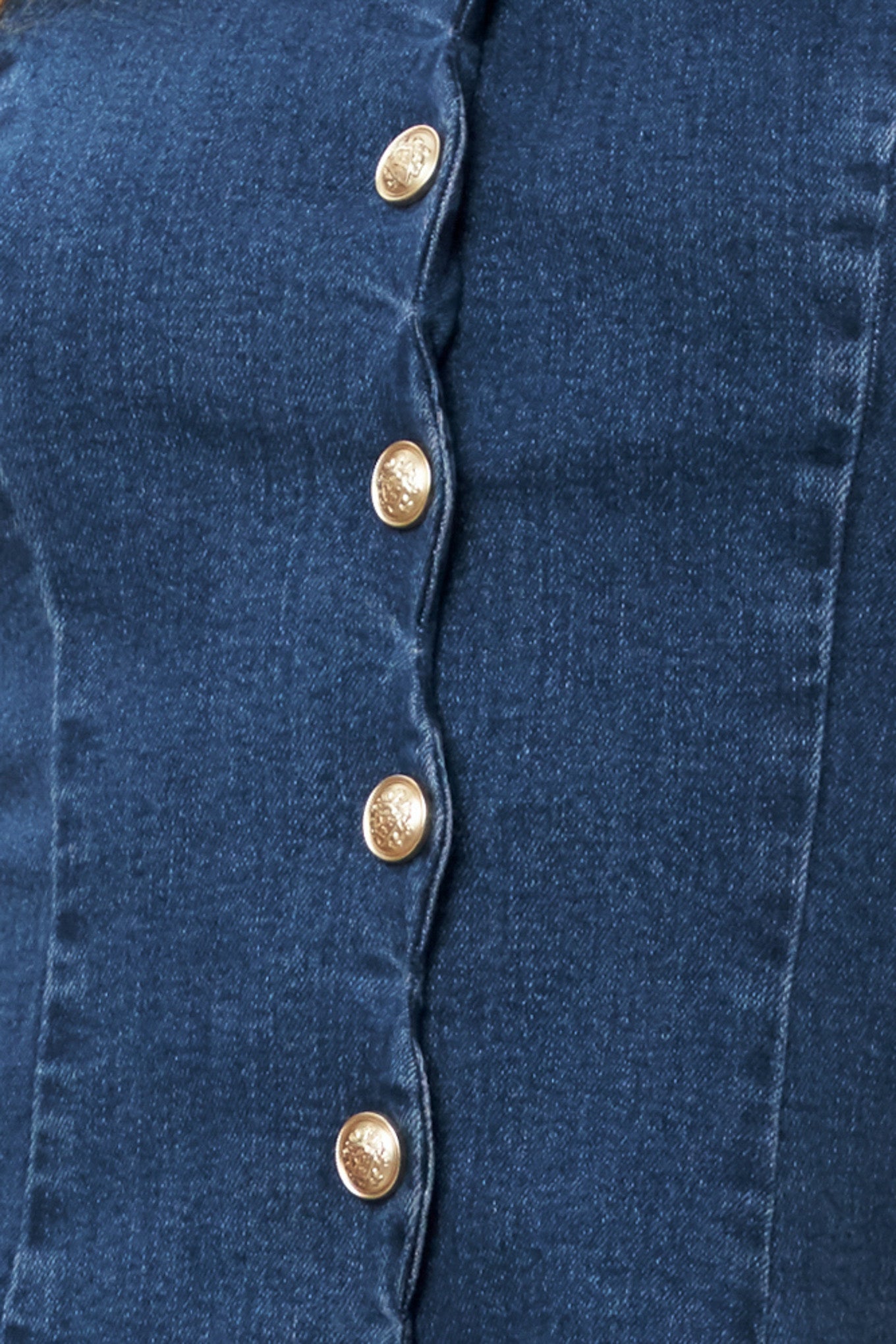 Close-up of a blue denim fabric with gold buttons | Flying Tomato