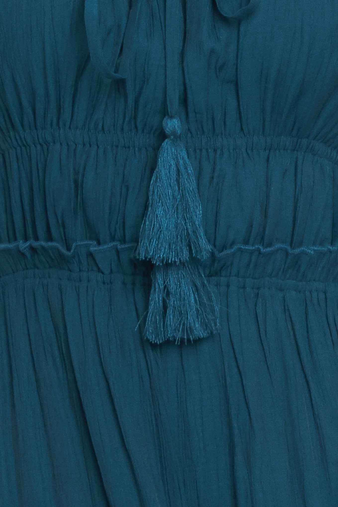 A solid woven maxi dress featuring straight neckline, front tie/tassel, straps, elastic at empire, tier skirt, bare back with straps