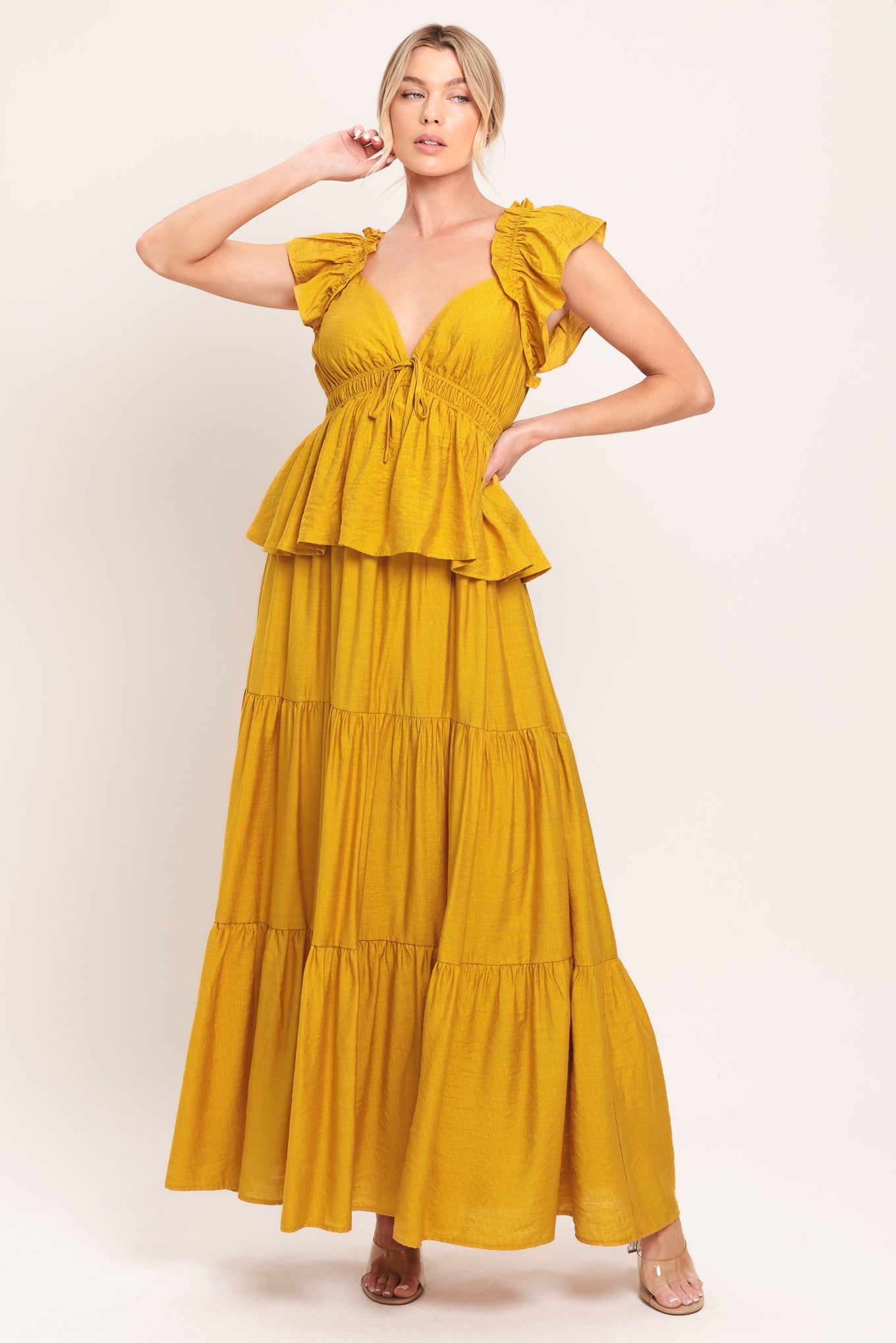 Woman wearing a mustard yellow tiered maxi dress featuring sweetheart neckline, short ruffle sleeve, and elastic empire | Flying Tomato