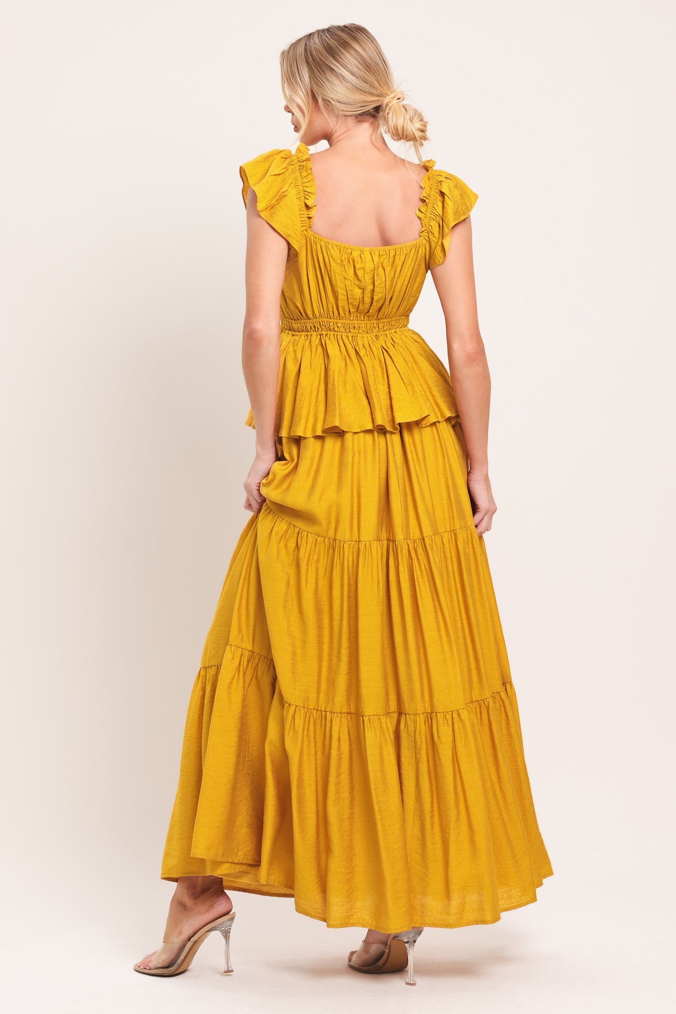 Woman wearing a mustard yellow tiered maxi dress featuring sweetheart neckline, short ruffle sleeve, and elastic empire | Flying Tomato
