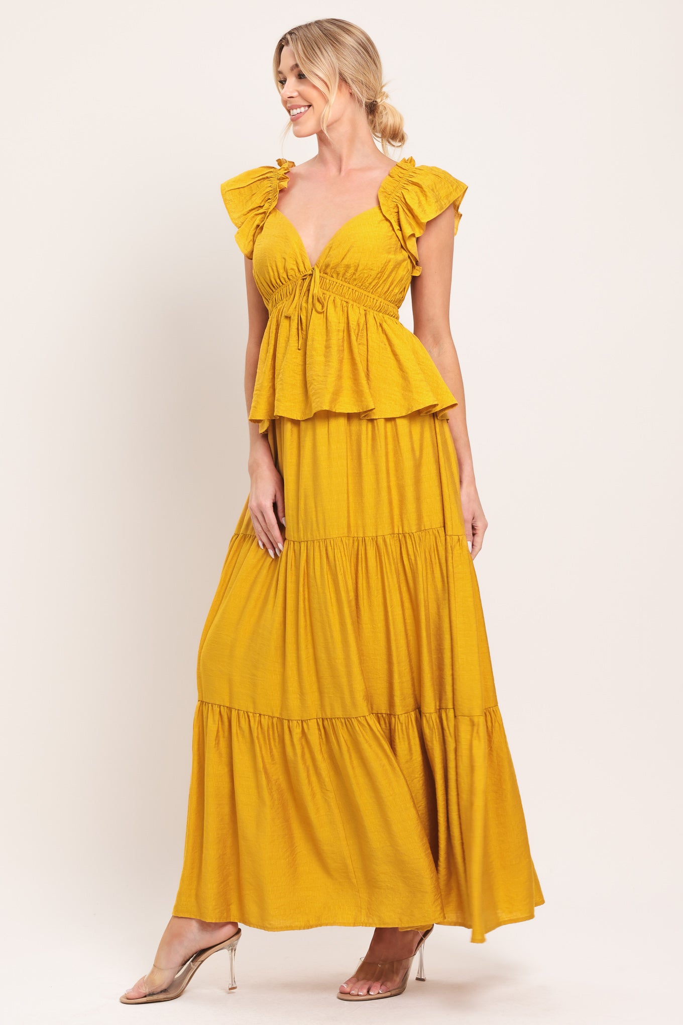 Woman wearing a mustard yellow tiered maxi dress featuring sweetheart neckline, short ruffle sleeve, and elastic empire | Flying Tomato