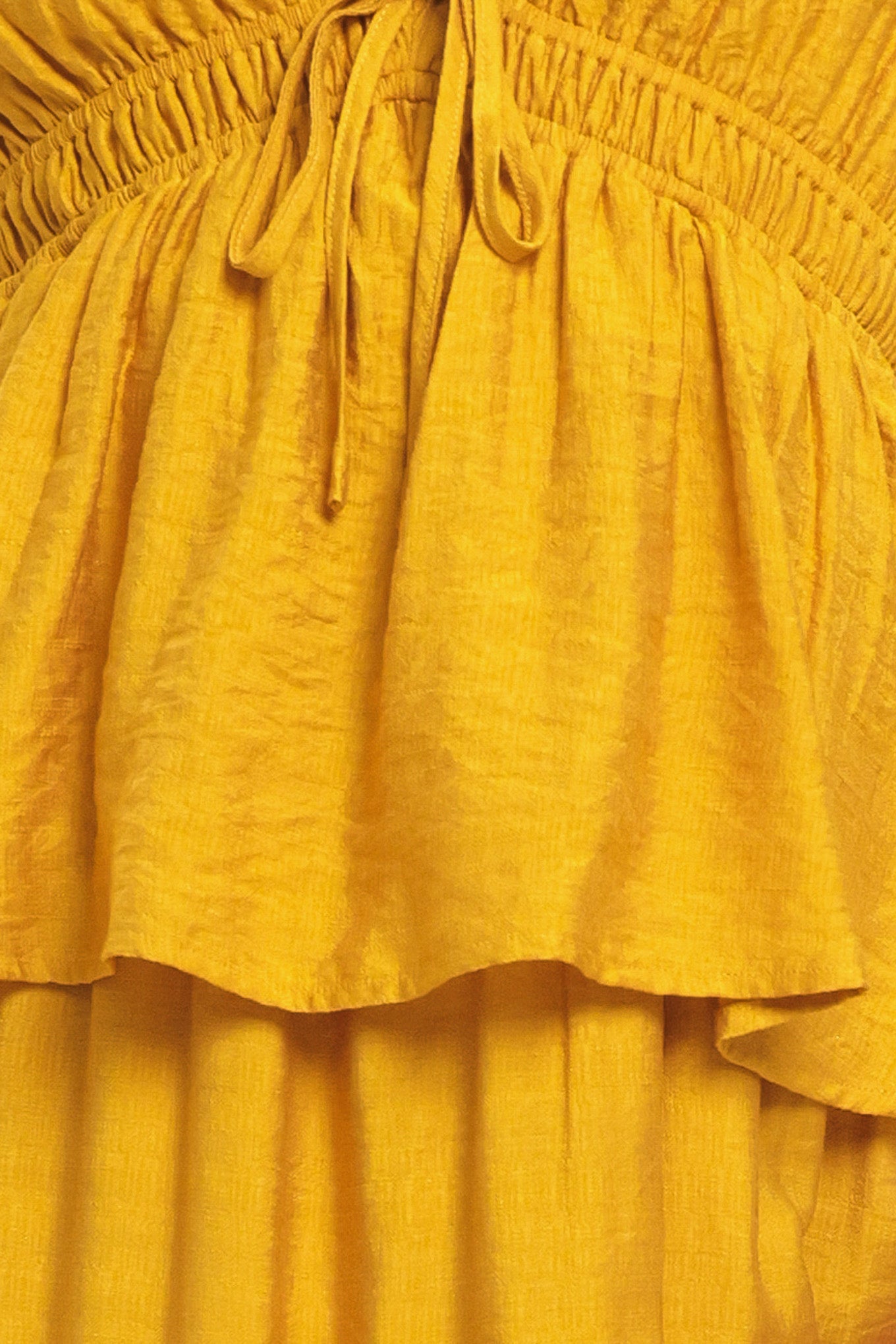 Woman wearing a mustard yellow tiered maxi dress featuring sweetheart neckline, short ruffle sleeve, and elastic empire | Flying Tomato