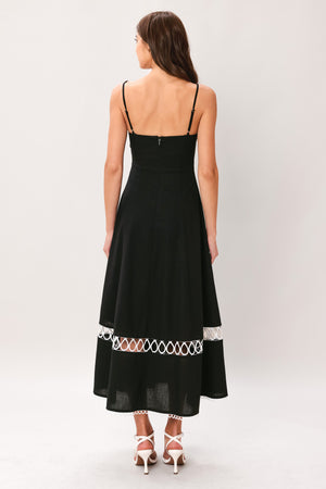 Woman wearing a black midi dress featuring straight neckline with lace edge trim, straps, circle skirt with lace inset bottom, lace edge trim and back zipper closure | Flying Tomato