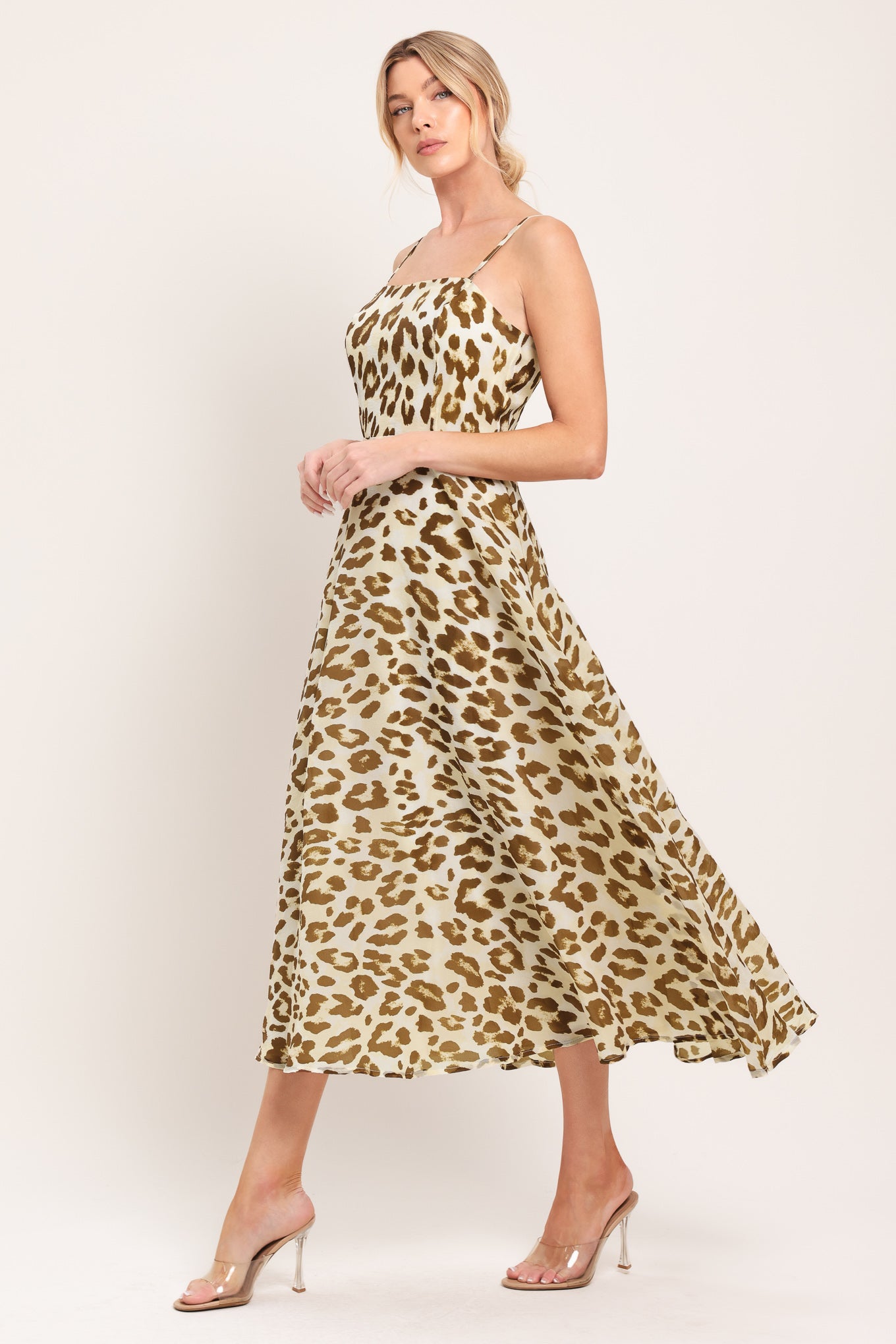Woman wearing a leopard print midi dress featuring straight neckline, straps, full circle skirt and back zipper closure | Flying Tomato