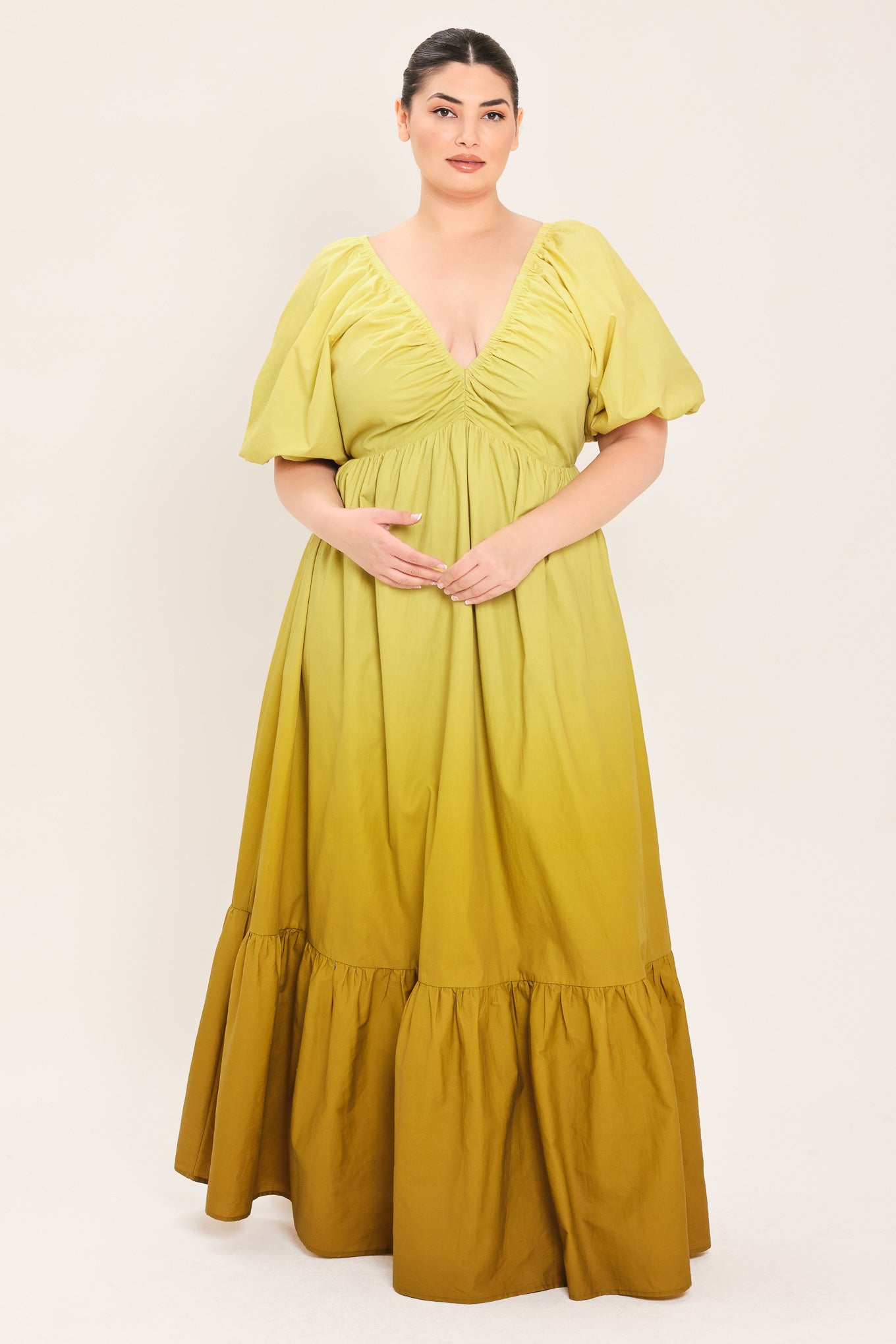 A woman modeling a yellow midi dress with puff sleeves, a deep V-neckline, and a gathered skirt with a tiered hem | Plus Curve Flying Tomato