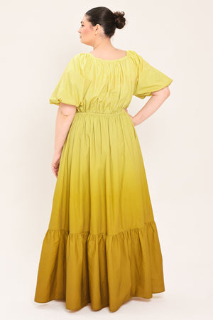 A woman modeling a yellow midi dress with puff sleeves, a deep V-neckline, and a gathered skirt with a tiered hem | Plus Curve Flying Tomato
