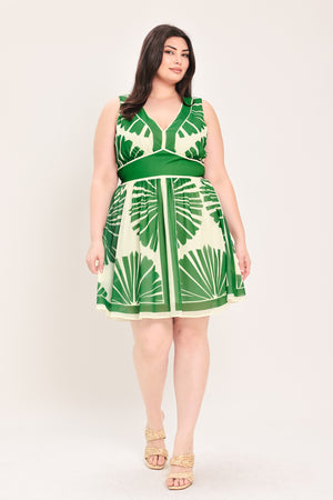 Woman wearing a sleeveless ivory with green leaf pattern mini dress featuring V neckline, full skirt and smocked back waistband | Flying Tomato