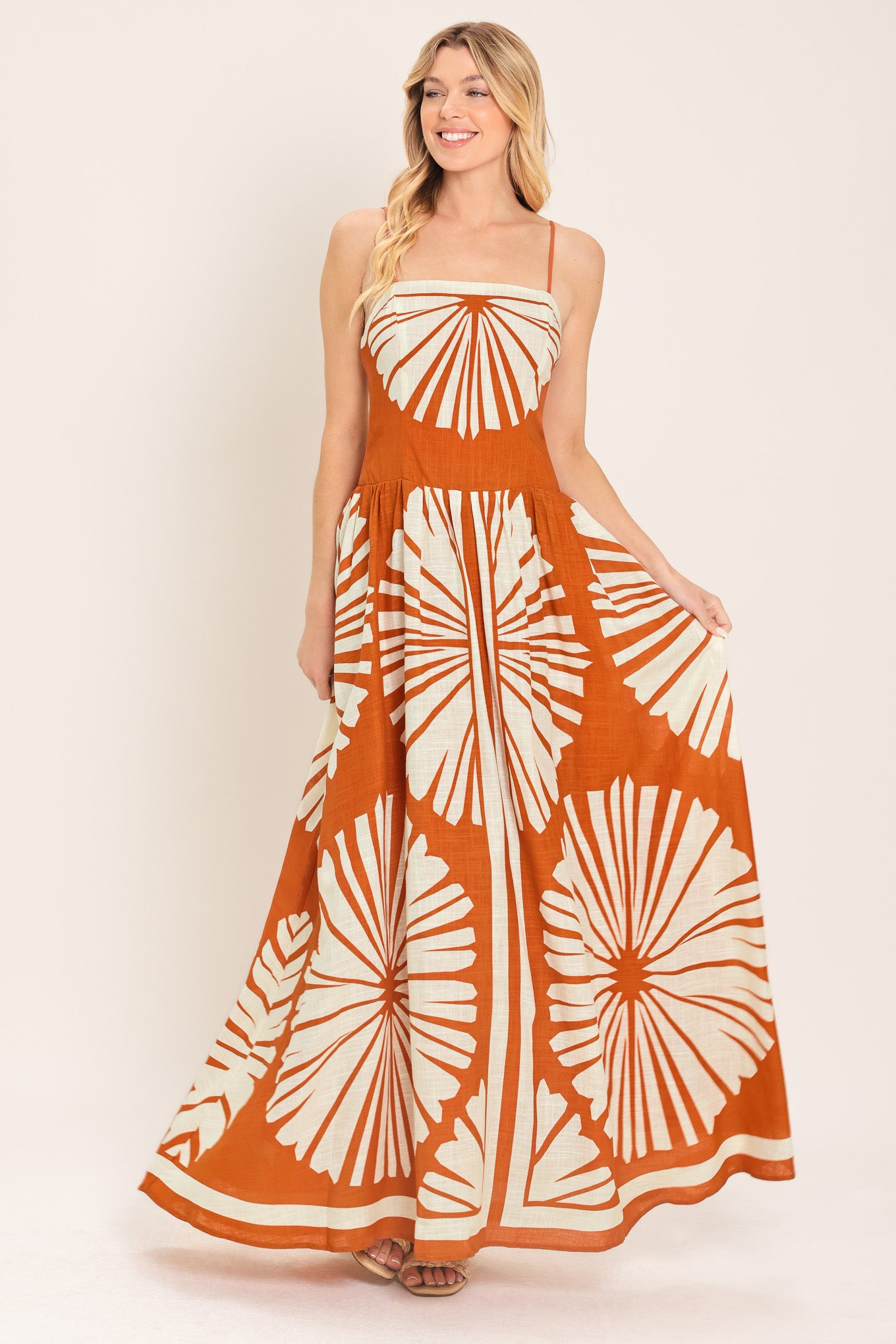Woman wearing a maxi dress with an almond orange and white pattern | Flying Tomato
