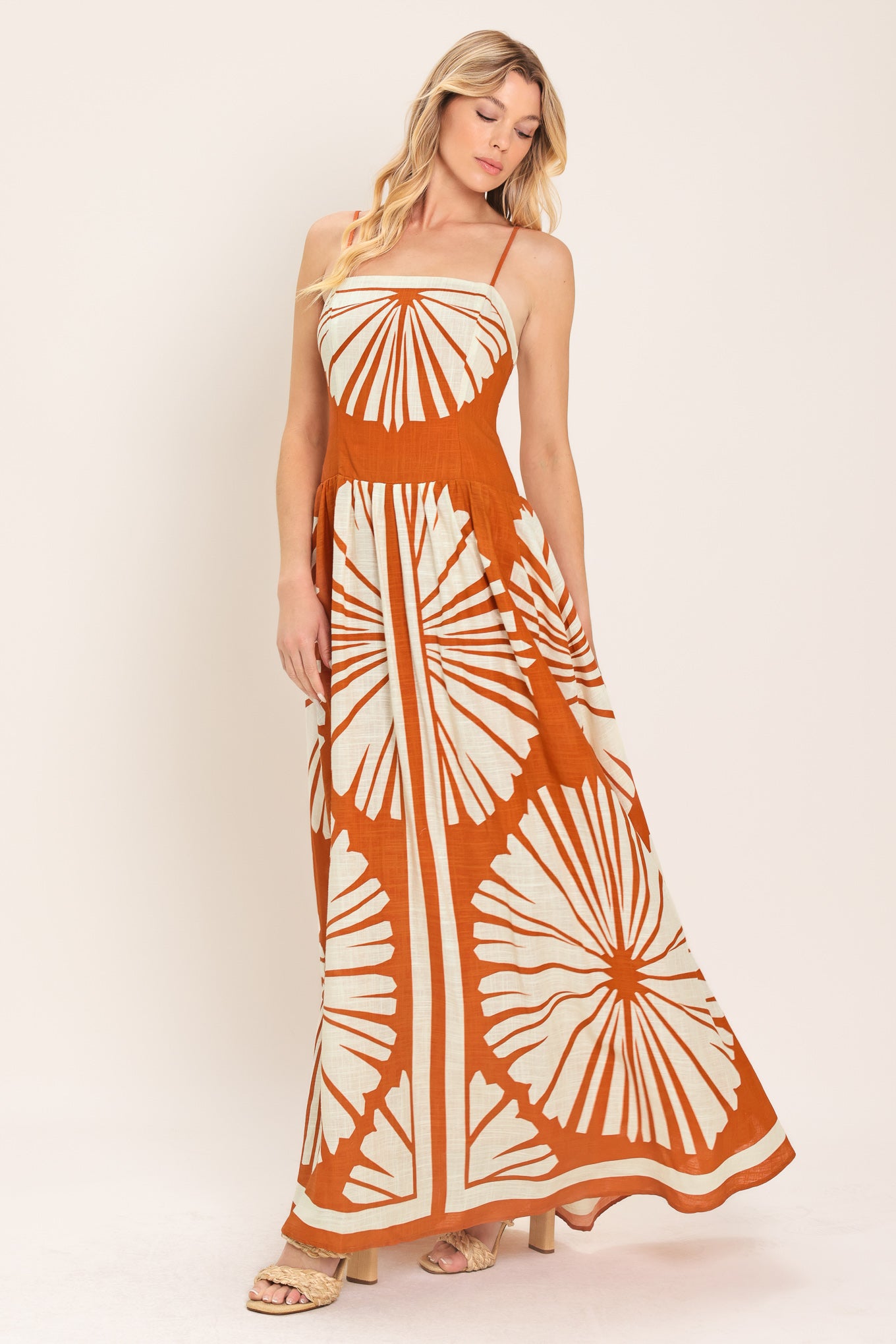 Woman wearing a maxi dress with an almond orange and white pattern | Flying Tomato